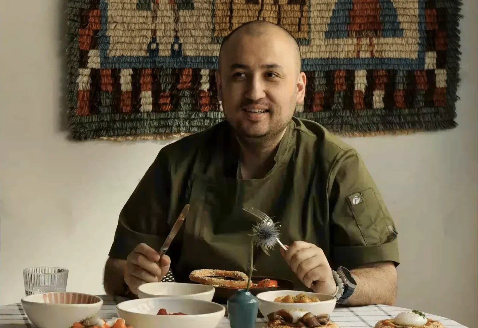 Шеф-повар Бахтияр Шамсиев за столом с блюдами греческой кухни